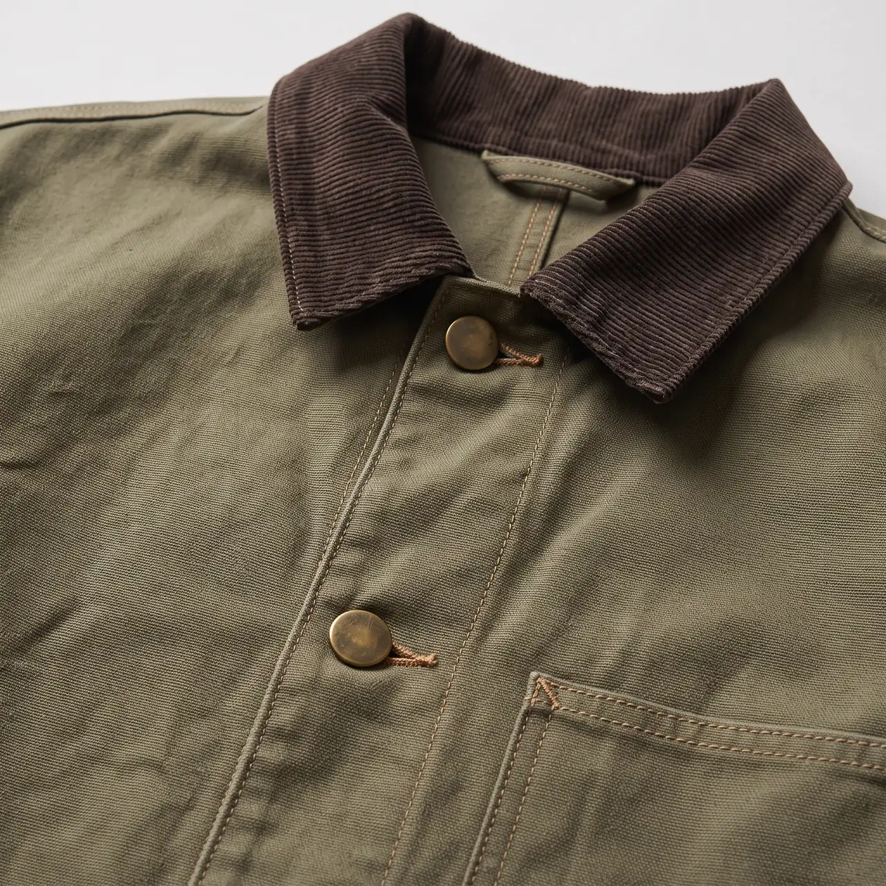 Nano Banana 2 output: close-up of the brown corduroy collar, plain brass buttons and tan double topstitching on olive canvas
